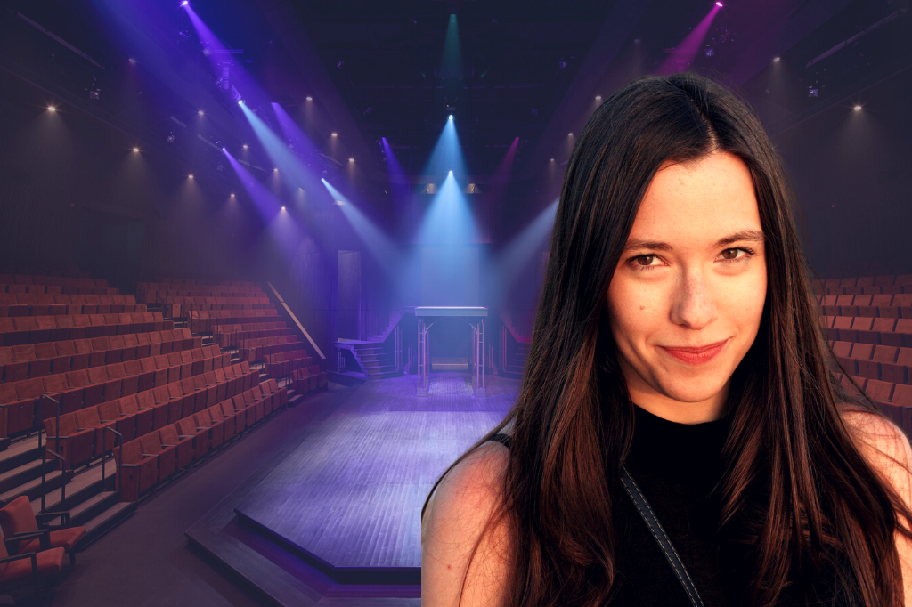 An image of Kayla Besse superimposed over the stage of Stratford Festival's new Tom Patterson Theatre. Stage stage is lit with blue lights, creating a purple aura over the red chairs. Kayla has long, straight brown hair, and wears a black tank top with a high neck. She smiles softly, looking at the camera.