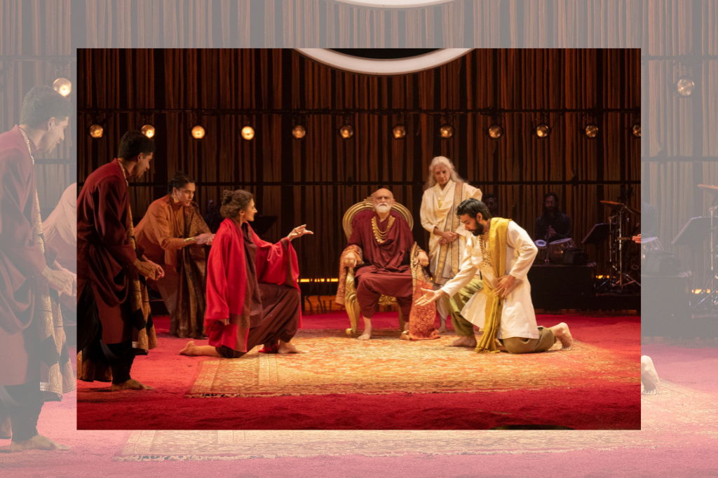 Men and women kneel and sit on stage in red and white robes.