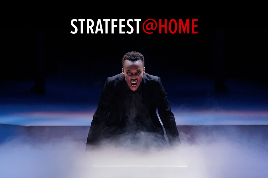 Amaka Umeh as the titular prince in Stratford Festival's 2022 production of Hamlet. She crouches onstage, facing the camera, shouting intently at her audience. Smoke billows from the stage around her hands. Above her head is the red and white logo for STRATFEST@HOME. Original Photo by David Hou. Image courtesy of Stratford Festival.