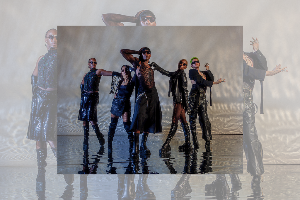 5 Dancers stand onstage wearing black leather and mesh costumes, sunglasses, and posing in dramatic yet casual stances.