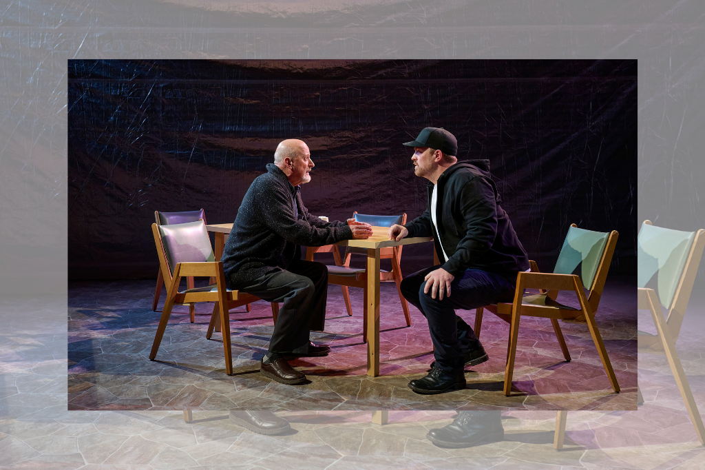Jim Mezon and Craig Pike perform in Caryl Churchill's A Number, presented by That Theatre Company. The men are seated at a small table, staring intently at one another: Mezon wears a dark knit cardigan and appears to be pleading with Pike, who is in a dark hoody and baseball hat. Photo by Michael Cooper.