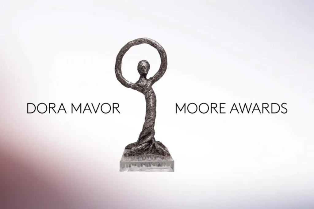 An image of a Dora Mavor Moore Award on a white background. The statue displays a bronze humanoid figure, its arms raised above its head to create a circle. Surrounding the statue is text reading "Dora Mavor Moore Awards."