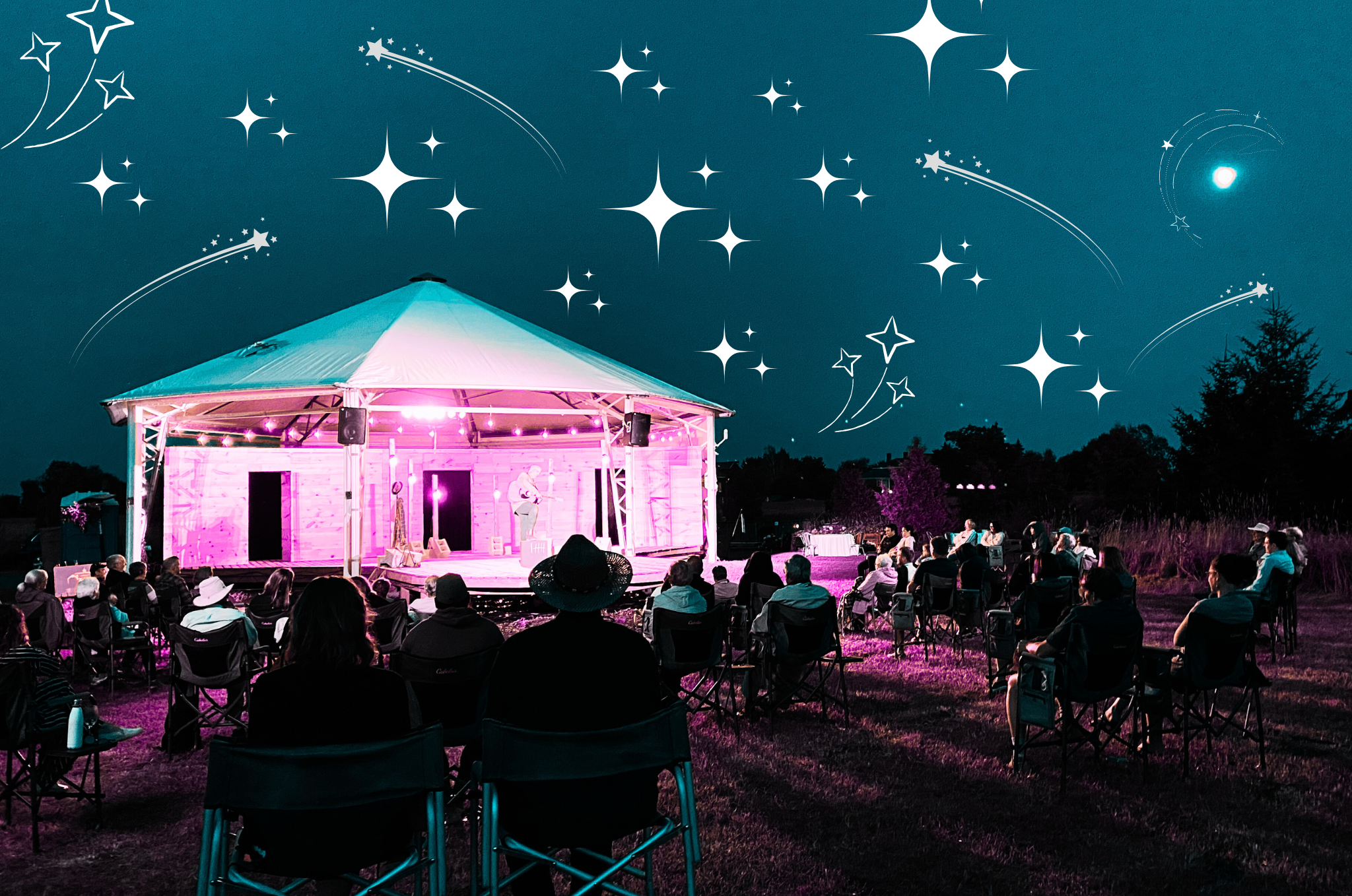 an audience sits in front of the eddie pavilion, taking in a show under a night sky. The image's colours have been altered -- the sky is a dark, tealy blue, and the pavilion glows pink in the night.