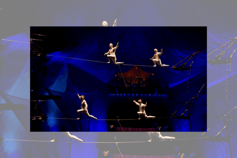 Four acrobats in white outfits balance on tightropes in the air. A blue tent background is behind them.