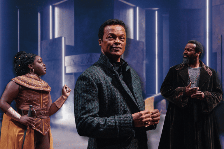 Three actors stand in front of a glowing set.