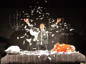 Main character throwing pillow feathers across the stage