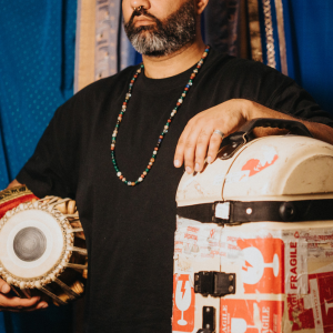 Nawaaz Makhani from the nose down with tabla under arm