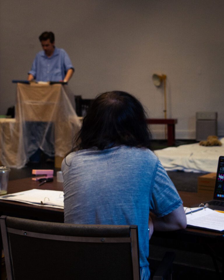 Director, Kenneth Gray, sat with his back turned to the camera, directing Charles Ford during rehearsals